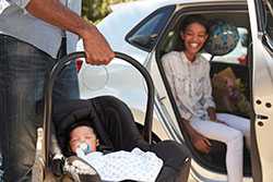 Father putting baby into car