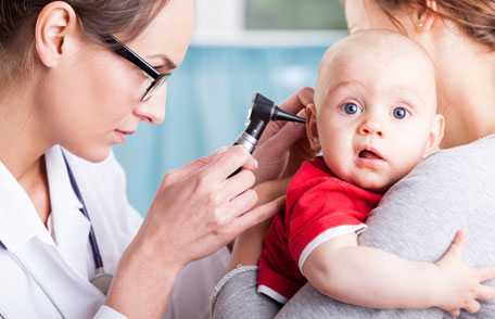 Doctor examining baby's ear