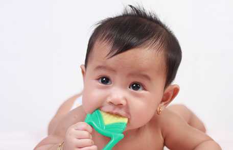 Baby chewing on toy