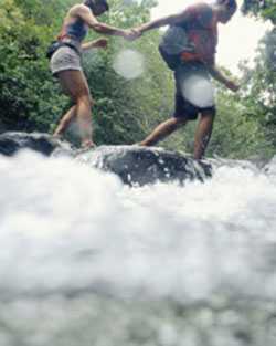 Two people walking through stream