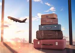 Suitcases in foreground with plane taking off in background