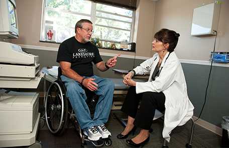 Jerry in wheelchair, talking with doctor