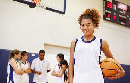 Teenage girl smiling at basketball game