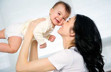 Mother holding and kissing baby