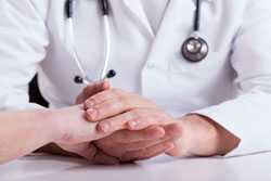 Doctor's hands consolding patient's hands