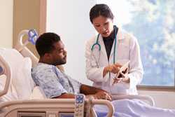 Doctor talking with patient in hospital bed