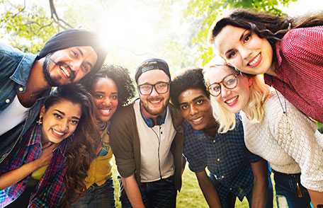 Group of young adults cutting up fruits and vegetables