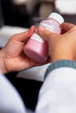 Photo: Pharmacist holding bottle of medicine