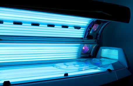 Young woman lying in tanning bed