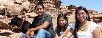 Three Native American youths with their dog