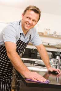 Photo: A mna cleaning a counter top.