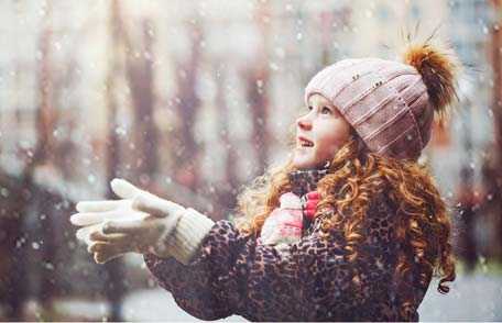 Young girl catching snowflakes