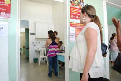 A pregnant woman waits in the doorway of a clinic to receive her vaccine. Brazil. 2014-2015 season.