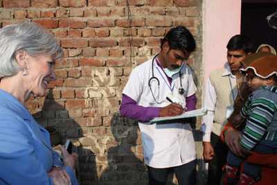 Secretary Sebelius listening to a field staff nurse taking a history from the child’s family.