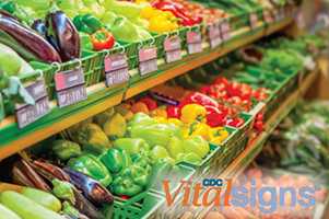 Grocery store shelf filled with vegetables.