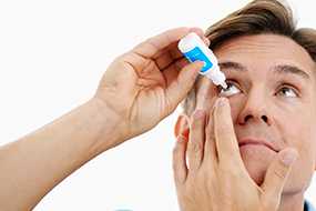 	Man Applying Eye Drops.