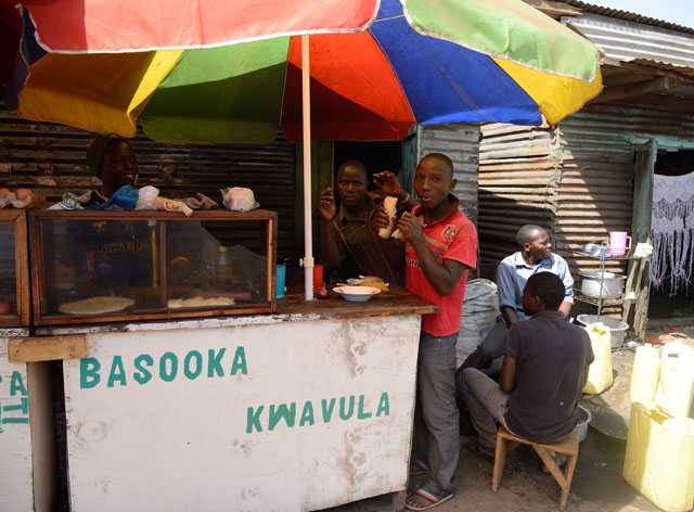 Young men eating chapatti. 