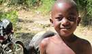 A boy by a road in Haiti, where geographic information systems save lives and money for healthcare facilities (Source: CDC)