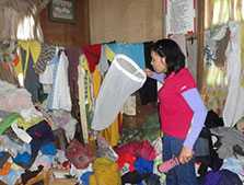 An entomologist examining whether an adult mosquito was caught amidst a sea of clothes. Photo taken during an entomologic survey conducted during a Chikungunya virus fever outbreak. Davao City, Philippines, October 2011.