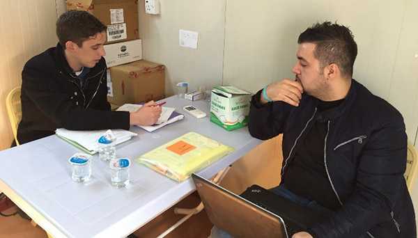 	ERRB EIS officer Andrew Boyd interviews a data manager participating in EWARN surveillance system at a clinic providing care to internally displaced persons. 