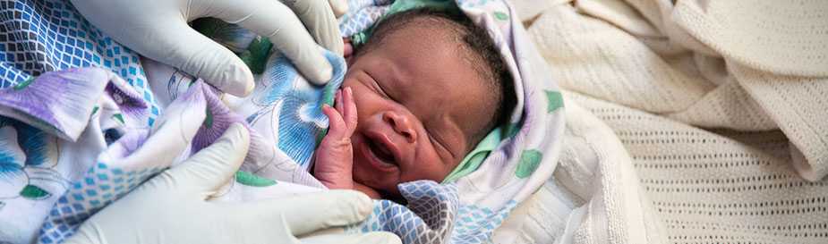 Health care worker caring for newborn baby