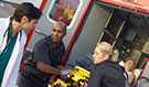 A doctor and emergency medical technicians removing a patient on a stretcher from an ambulance