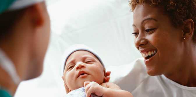 mother with newborn baby and health care worker