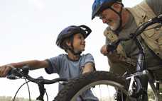 Grandson and Grandfather on bikes with helmets