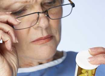 	Senior adult reading a pill bottle.