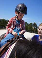 Boy being placed on a horse