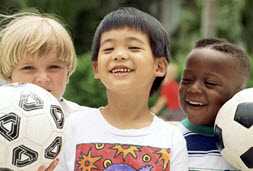 3 happy kids holding 2 soccer balls