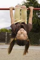 girl hanging on monkey bars