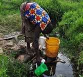 	A woman collecting water from a river in Kenya