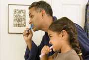 Father and daughter brushing teeth