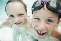 A boy and girl in a swimming pool.