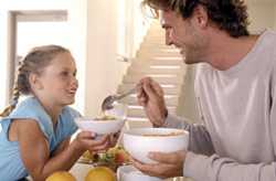 	man and girl eating cereal