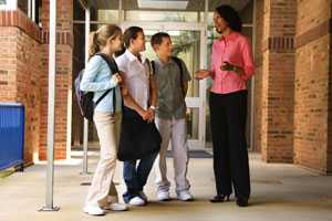 African American female teacher speaking with students