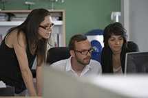 photo of several people gathered around a computer