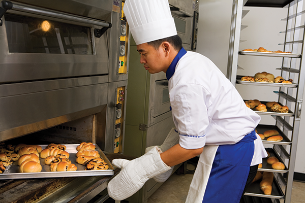 photo of a baker loading an oven