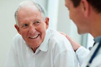 Photo: Male doctor talking with an older adult male patient