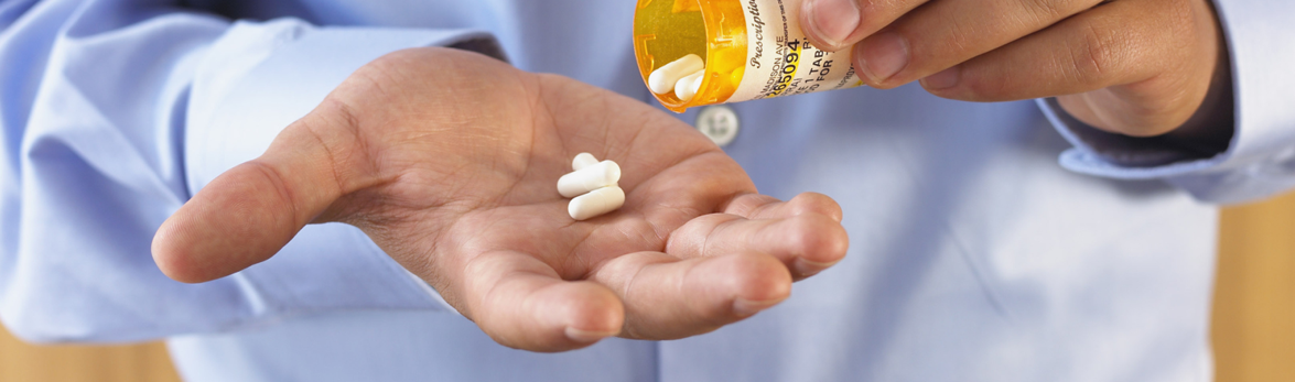 Man pouring pills from a pill bottle