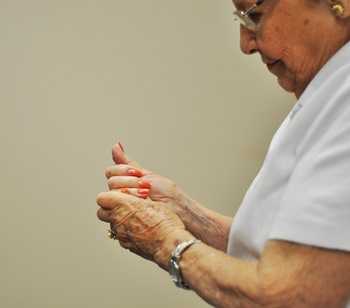 an older woman rubbing her hands in pain