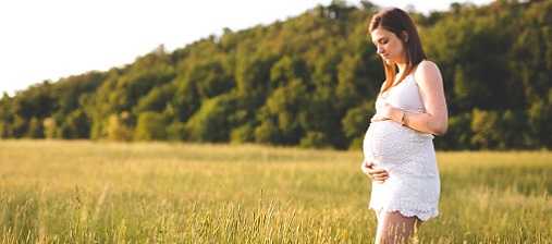 pregnant woman standing in a field