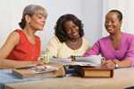 Three woman looking at documents