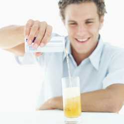 Man pouring an orange beverage.