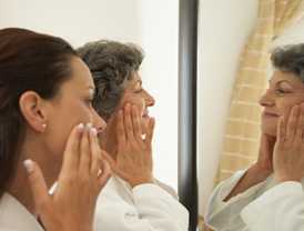 Photo: two woman looking in the mirror