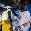 a nurse in protective clothing prepares to draw blood from patients at the Ebola Treatment Unit