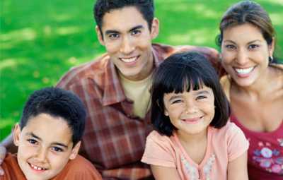 Photo: Smiling family on green grass.