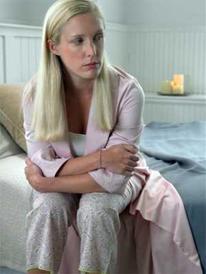 Photo: Woman sitting on her bed