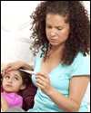 A mother checks her daughter's temperature with a thermometer.